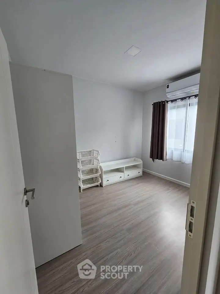 Minimalist bedroom with wooden flooring and natural light