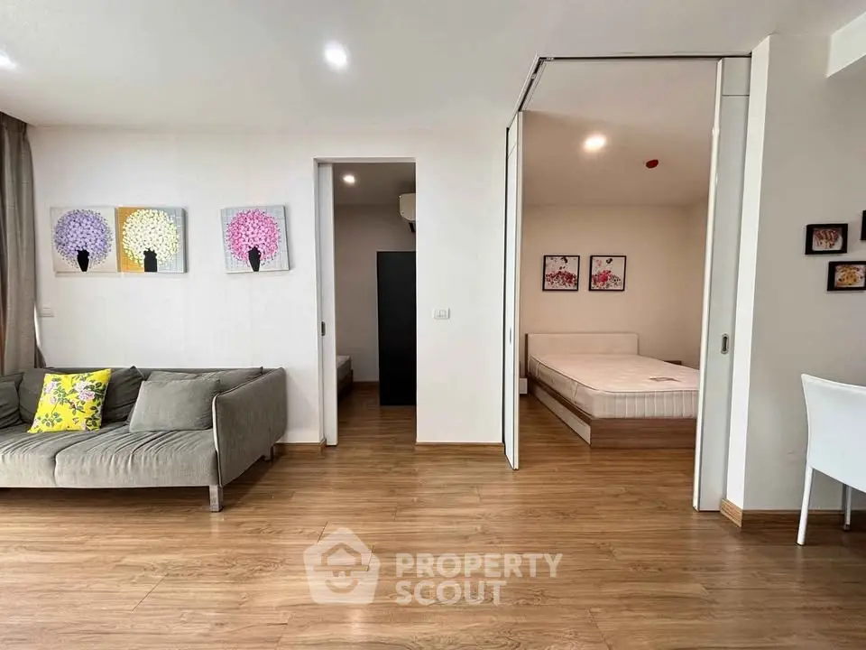 Modern living room with wooden flooring and cozy bedroom view