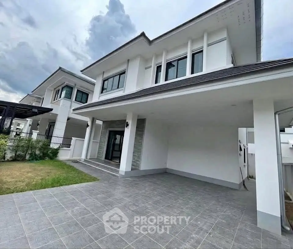 Modern two-story house with spacious driveway and contemporary design.