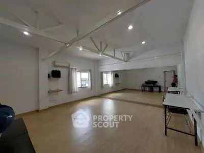 Spacious multipurpose room with wooden flooring and large mirrors, ideal for dance or yoga.