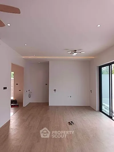 Spacious modern living room with large windows and wooden flooring