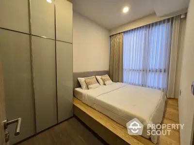 Cozy and modern bedroom with large wardrobe and natural light filtering through sheer curtains, perfect for restful nights in a serene environment.