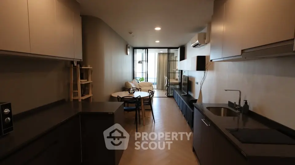 Modern open-plan kitchen and living area with sleek design and cozy seating.