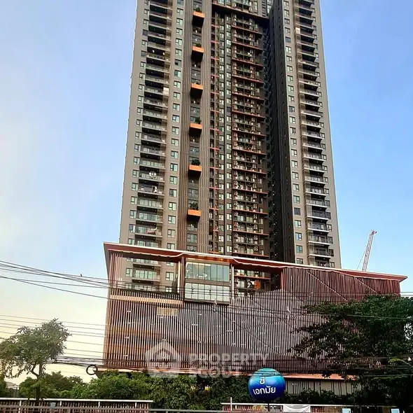 Stunning high-rise building with modern architectural design and lush greenery, perfect for urban living.