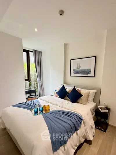 Modern bedroom with stylish decor and natural light, featuring a cozy bed and elegant furnishings.