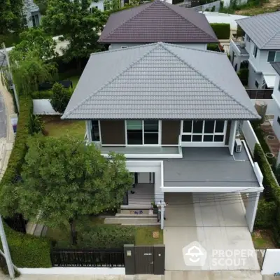 Modern two-story house with a spacious driveway and lush greenery in a serene neighborhood.