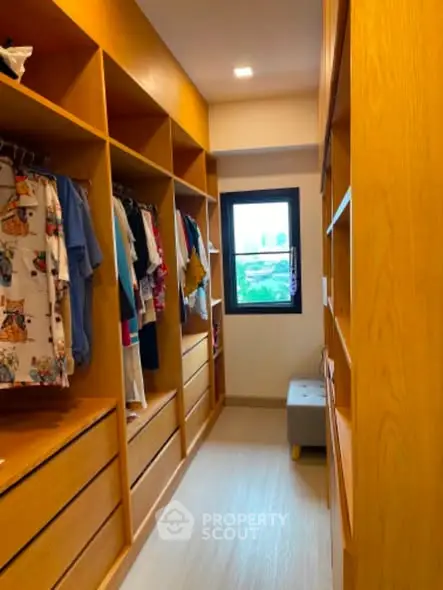 Spacious walk-in closet with wooden shelves and natural light