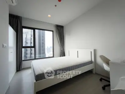 Modern minimalist bedroom with city view, featuring a sleek bed and study desk, perfect for urban living.