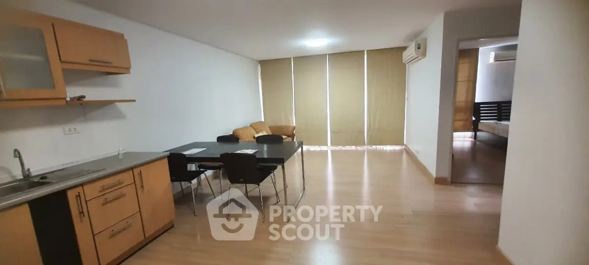 Spacious open-plan living and dining area with modern kitchen in a stylish apartment.