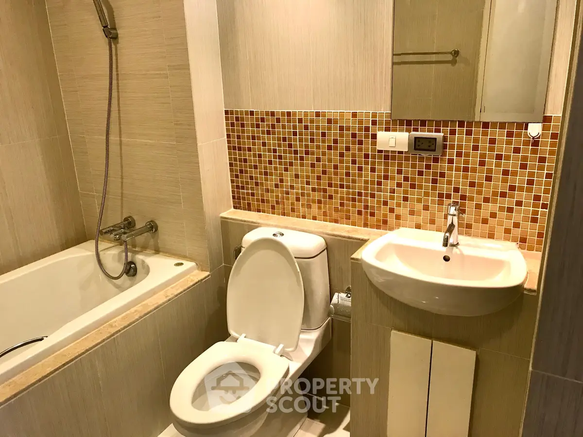 Modern bathroom with bathtub and stylish mosaic tiles, perfect for relaxation and comfort.