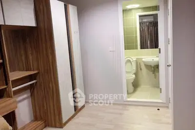 Modern apartment interior with wooden wardrobe and bathroom view, showcasing sleek design and functionality.