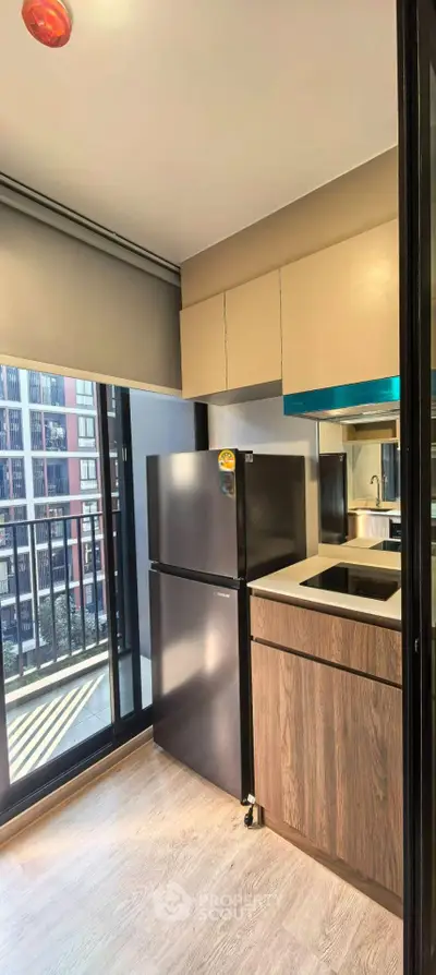 Modern kitchen with sleek cabinets and balcony view in urban apartment