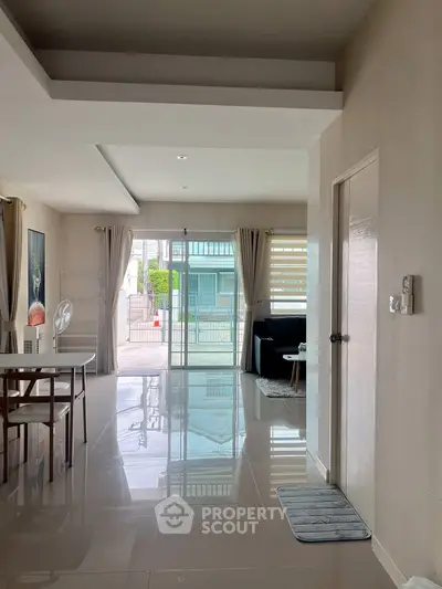 Spacious modern living room with glossy floors and large windows for natural light.