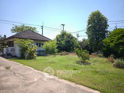 Charming single-story house with lush green garden and spacious driveway.