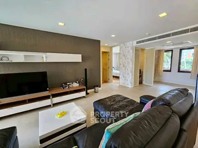 Spacious modern living room with leather sofa and entertainment center
