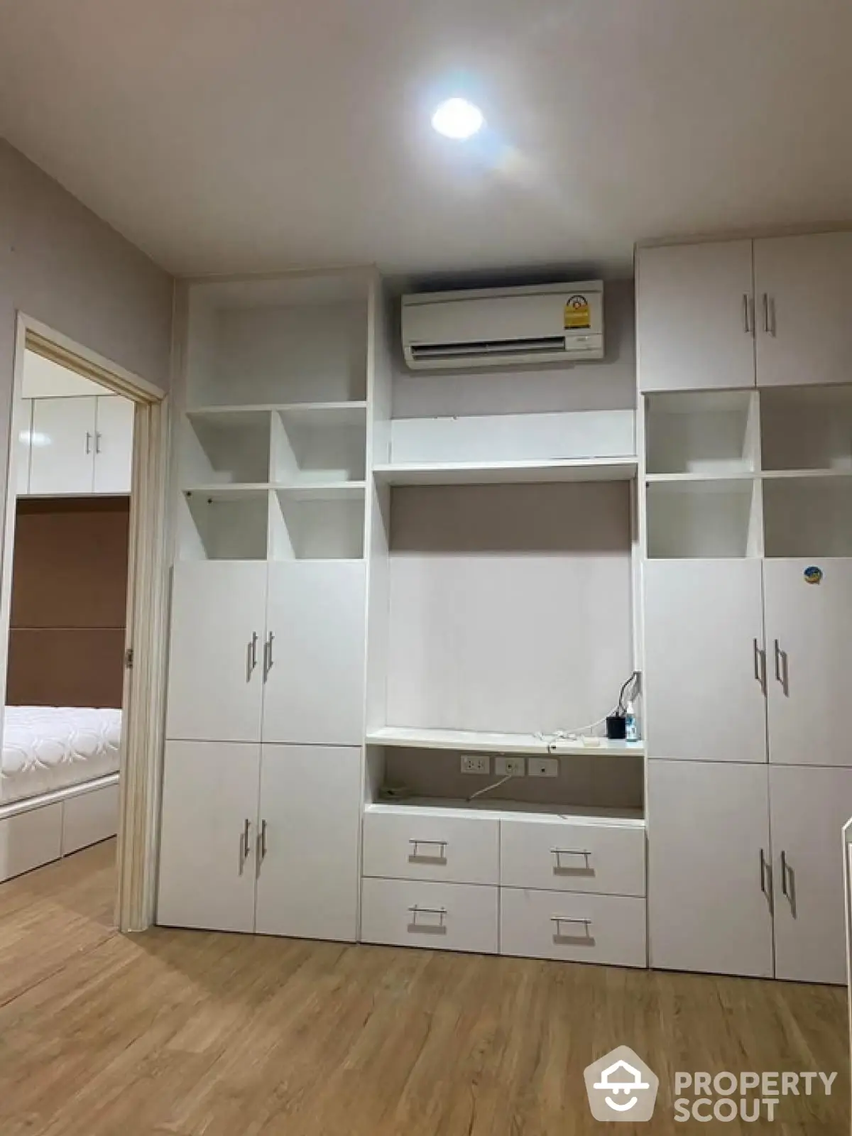 Modern bedroom with built-in white cabinetry and air conditioning unit