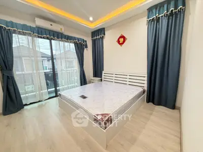 Spacious bedroom with large windows and modern decor in a stylish home.