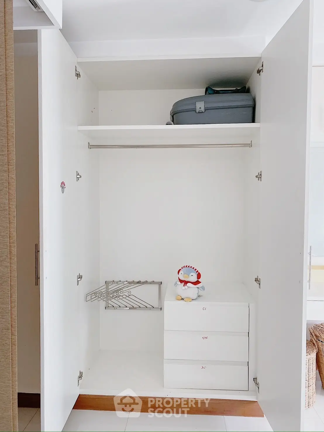 Spacious white wardrobe with drawers and hanging space in modern interior.
