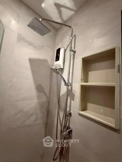 Modern bathroom with sleek shower and built-in shelving, perfect for contemporary living.