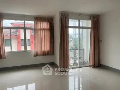 Spacious empty room with large windows and balcony access, perfect for customization.