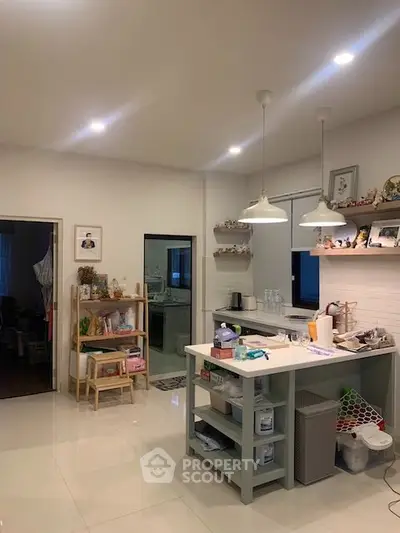 Charming kitchen with open layout and modern lighting, featuring ample storage and sleek countertops.