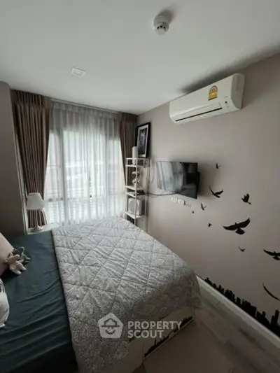 Cozy bedroom with modern decor and wall-mounted TV, featuring a large window for natural light.