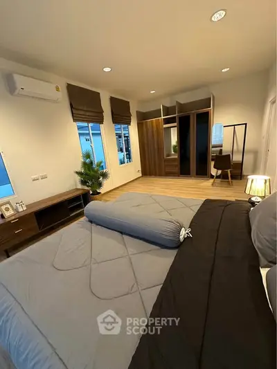 Spacious modern bedroom with stylish decor and ample natural light.