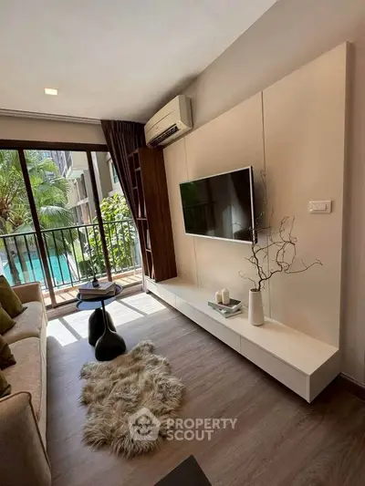 Modern living room with pool view, stylish decor, and natural light.