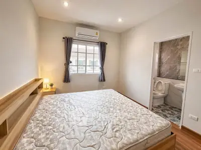 Spacious bedroom with ensuite bathroom in modern apartment