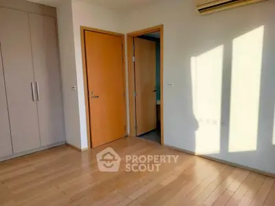Spacious bedroom with wooden flooring and built-in wardrobe, perfect for modern living.