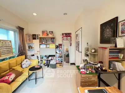 Cozy living room with bright yellow sofa, modern shelving, and ample natural light.