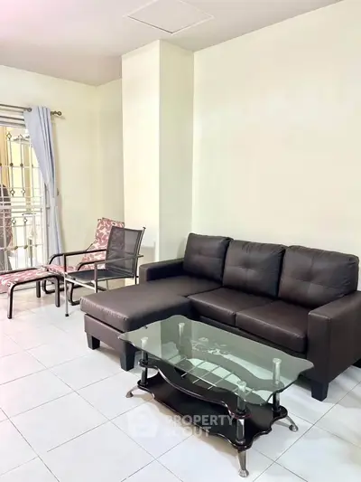 Spacious living room with modern sofa and glass coffee table in a bright interior.