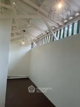 Charming attic space with unique lighting and sloped ceiling, perfect for creative use.