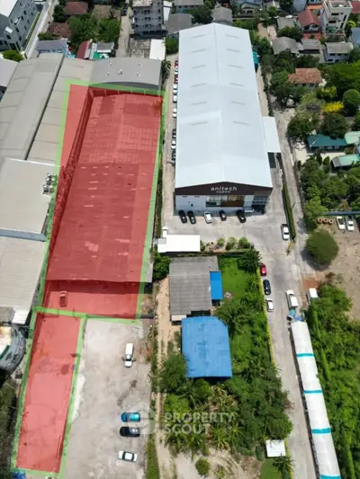 Aerial view of industrial warehouse complex with ample parking and surrounding greenery.