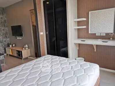 Modern bedroom with stylish decor and wall-mounted TV in a contemporary apartment.