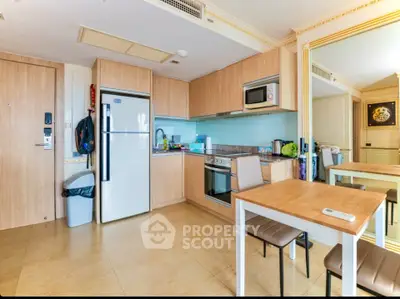 Modern kitchen with wooden cabinets, stainless steel appliances, and dining area in a cozy apartment.