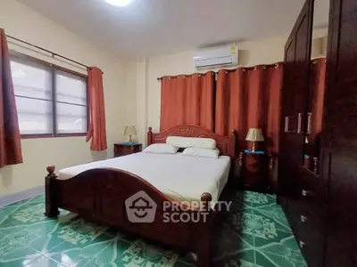 Cozy bedroom with wooden furniture and air conditioning, perfect for relaxation.