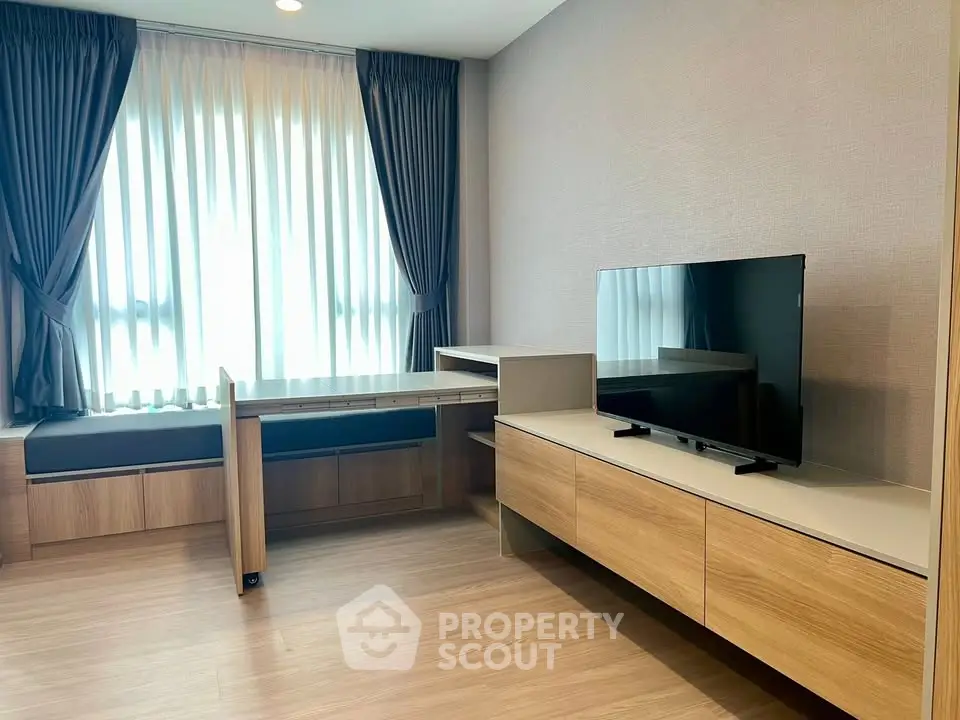 Modern living room with sleek wooden furniture and large TV, perfect for relaxation and entertainment.