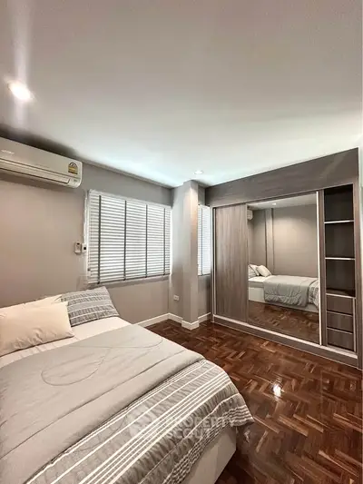 Spacious bedroom with mirrored wardrobe and parquet flooring