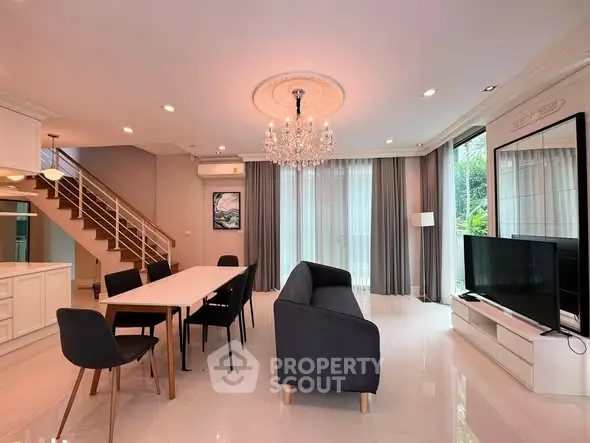 Luxurious open-plan living room with elegant chandelier and modern furnishings