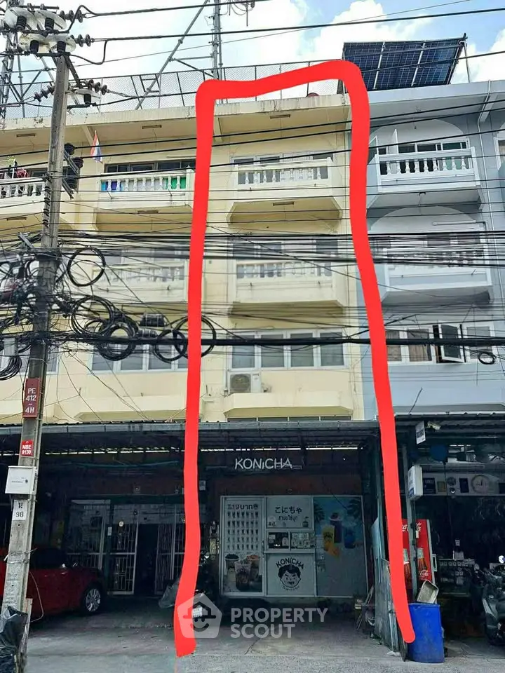 Commercial building with retail space on ground floor and residential units above.