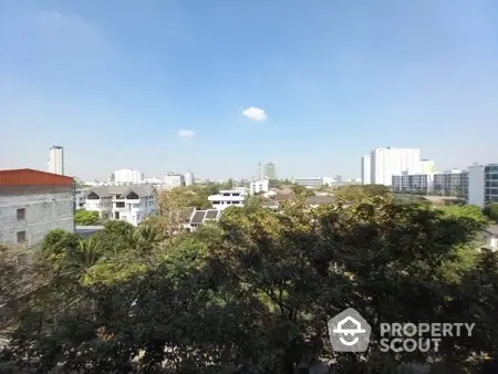 Stunning cityscape view with lush greenery and modern buildings under a clear blue sky.