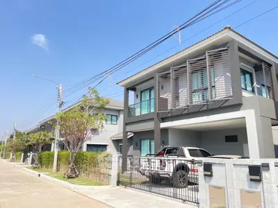 Modern two-story house with a sleek design and spacious driveway in a suburban neighborhood.