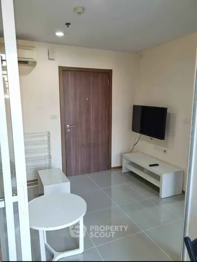 Modern living room with sleek TV setup and minimalist furniture in a stylish apartment.