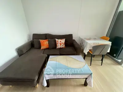 Cozy living room with modern sofa and dining area, perfect for urban living.