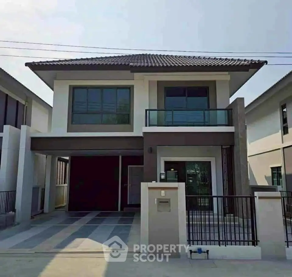 Modern two-story house with sleek design and spacious driveway in a suburban neighborhood.