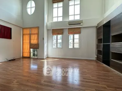 Spacious living room with high ceilings and large windows in modern apartment