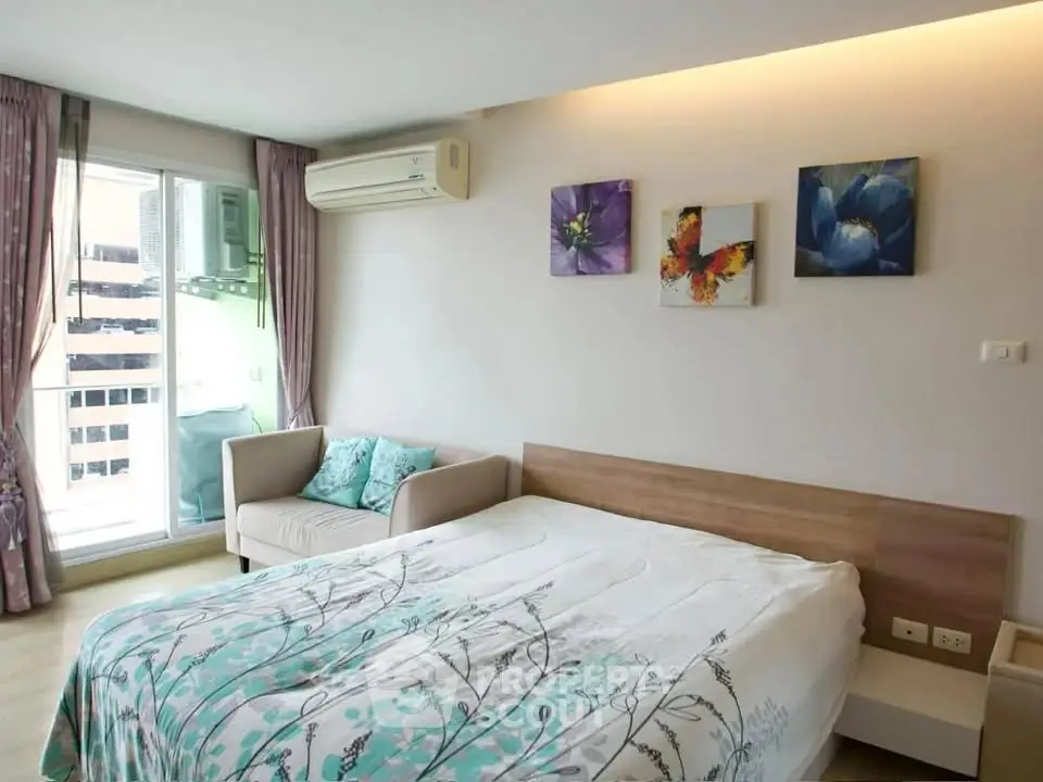 Modern bedroom with stylish decor and balcony access in a cozy apartment.