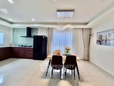Modern kitchen and dining area with elegant chandelier and sleek design