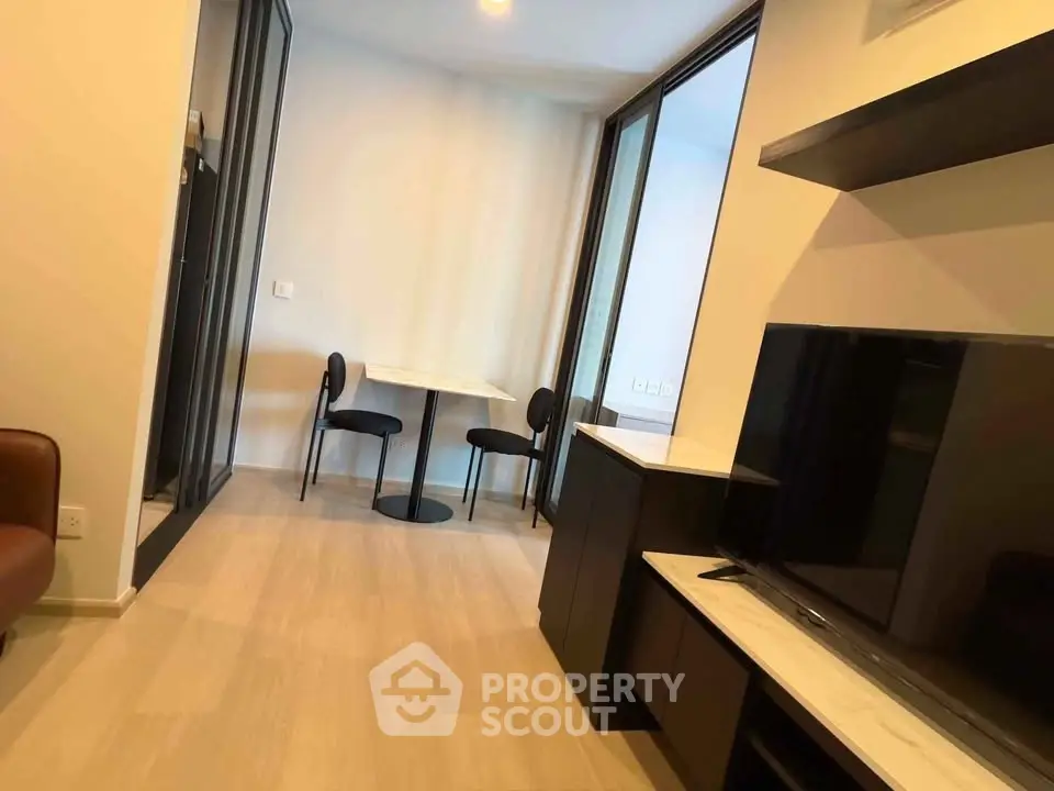 Modern living room with sleek furniture and dining area in a stylish apartment.